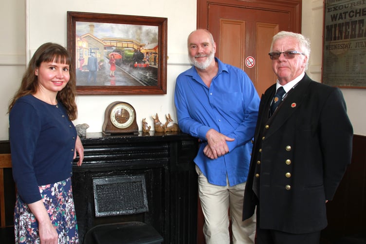 Williton station master Peter Payne and artist Tim Wetherell and wife Asia with the painting which has been hung in the waiting room. PHOTO: George Ody.
