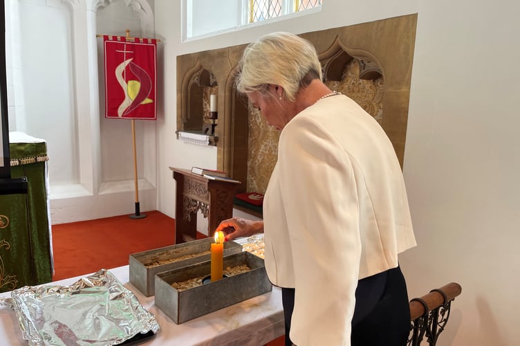 MP Rachel Gilmour lighting a candle at a service in St Andrew's Church, Minehead.