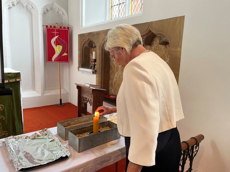 MP Rachel Gilmour lighting a candle at a service in St Andrew's Church, Minehead.