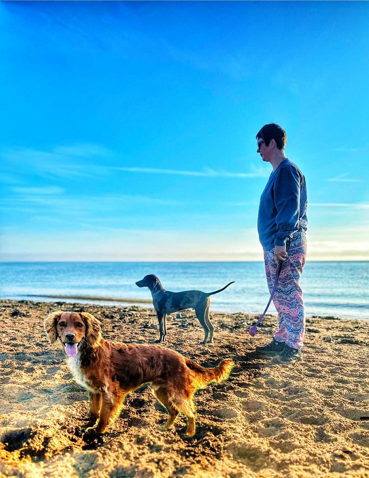 The Rev Chloe Kingdon walking her dogs on Dunster Beach, where last week she rescued her daughter and another child from drowning.