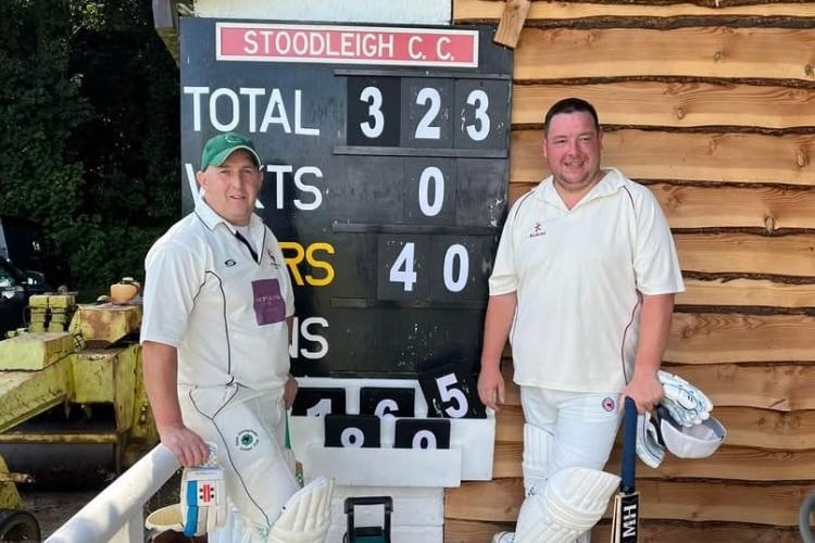 Cutcombe openers Mike Kidner (left) and Mark Matravers stand in front of the record breaking scoreboard