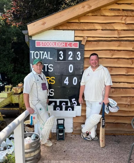 Cutcombe openers Mike Kidner (left) and Mark Matravers stand in front of the record breaking scoreboard