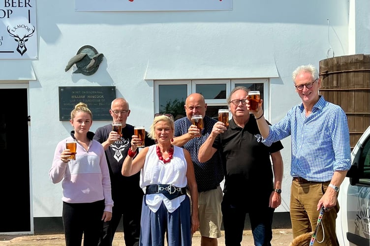 The New Exmoor Brewery team (left to right) Taiya Burgess with her dog Ace, Allan Bryant, Shaun Vockins, Jonathan Price, and Rupert Thompson with his dog Basil, raise a celebratory glass with  local MP Rachel Gilmour (front).
