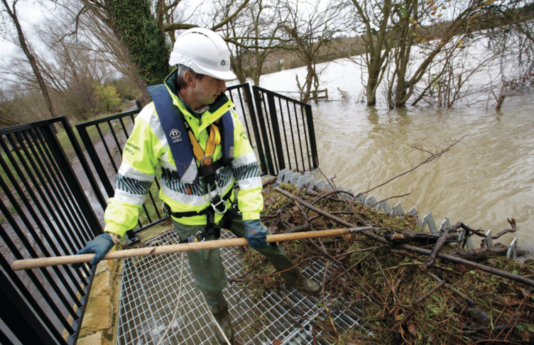 An Environment Agency worker carrying out flood prevention work on a river.