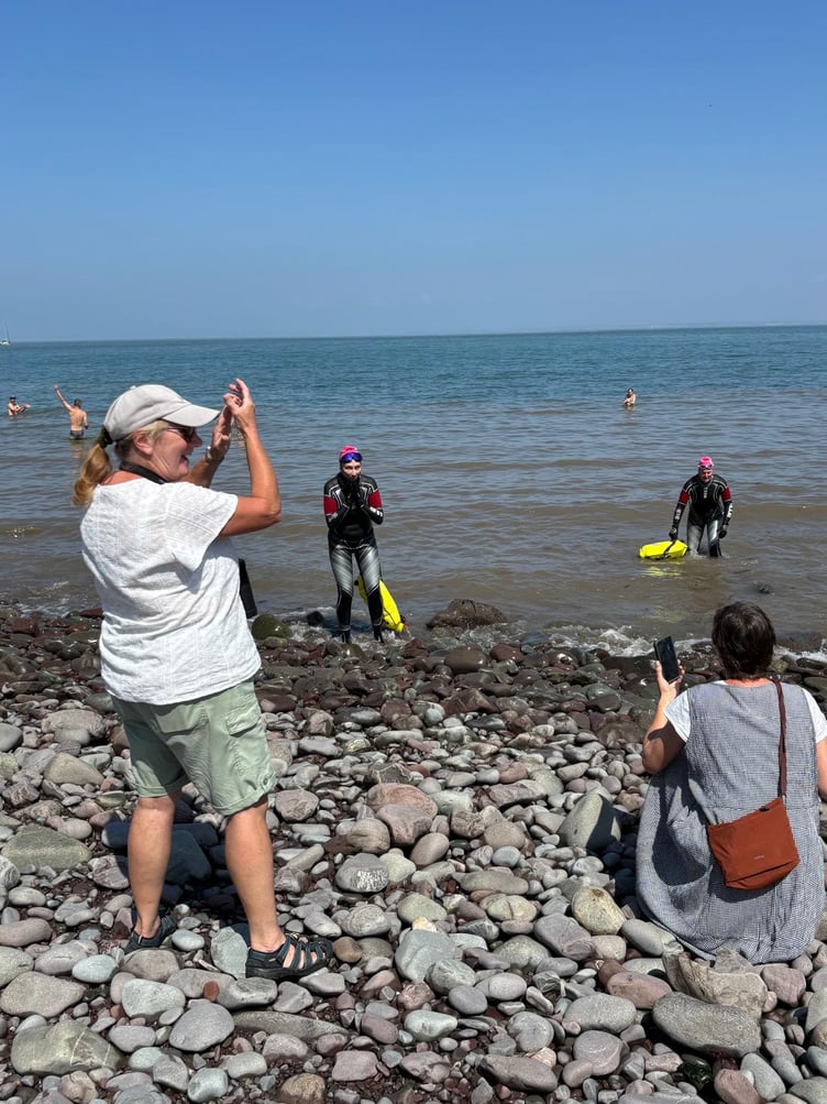 A welcome from friends and villagers awaited Sarah McLaughlin and Hannah Bays as they completed their Minehead to Porlock Weir swim.