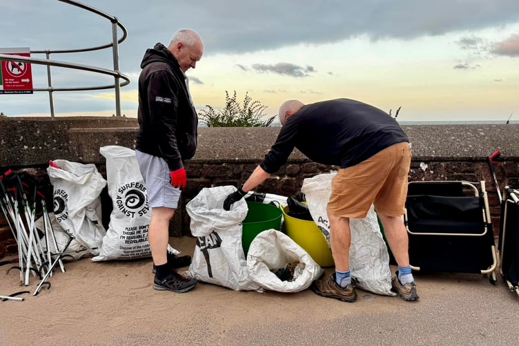 Keith Hunt and Peter Hoyland conduct an audit of items collected during a Minehead beach clean volunteer session.