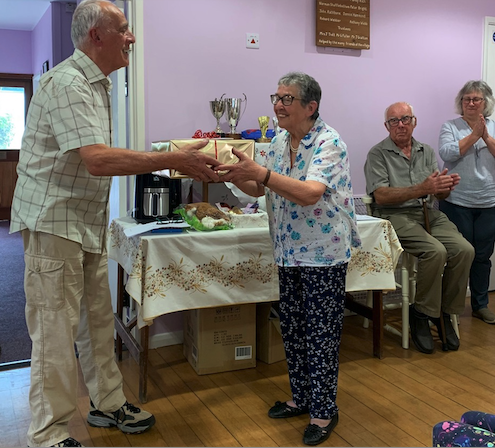 Joyce Smith receives a retirement presentation from Timberscombe Village Hall chairman Martin Booth after 36 years as caretaker.