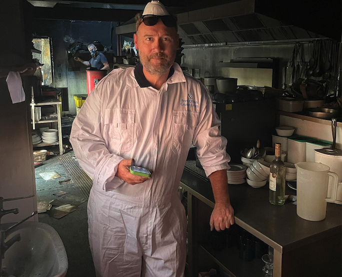 Justin Reeves in the fire damaged kitchen of his Dunster restaurant as a clean-up gets underway.