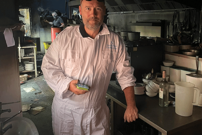Justin Reeves in the fire damaged kitchen of his Dunster restaurant as a clean-up gets underway.