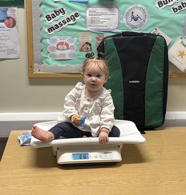 Young Evangeline is unfazed at being weighed with Home-Start West Somerset's new scales.