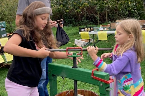 Minehead youngsters Darcy (six) and Bella (10) get stuck into the juicing process while father Ringo looks on