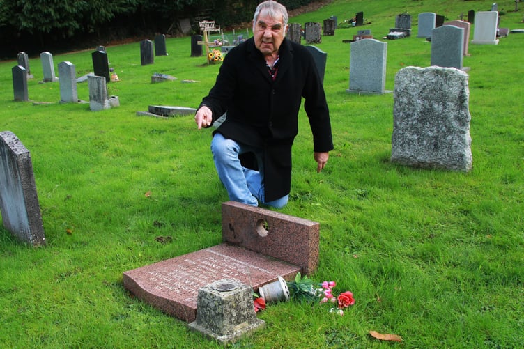 Richard Growden with a flattened headstone on somebody's grave in Porlock Cemetery. PHOTO: George Ody.