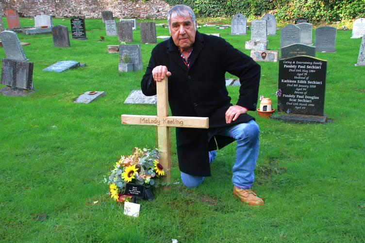 Porlock businessman Richard Growden with the wooden cross on his mother's grave. PHOTO: George Ody.