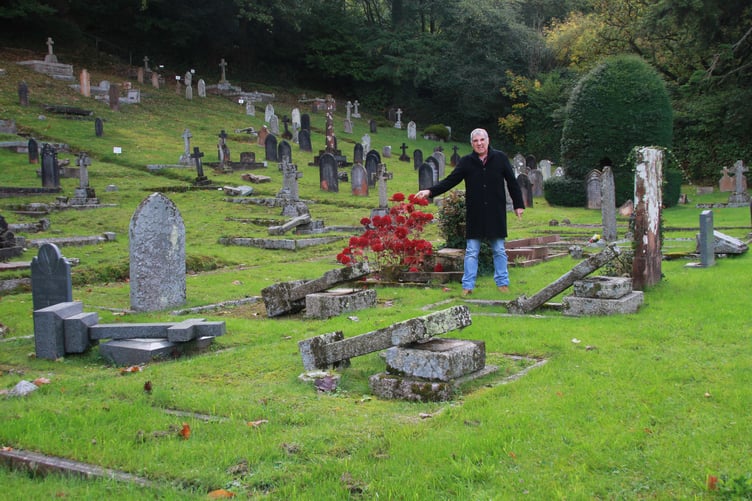 Porlock businessman Richard Growden surrounded by flattened gravestones in the village cemetery. PHOTO: George Ody.