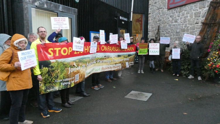 Protesters with a banner and placards attending a meeting of Watchet councillors to discuss a proposed Parsonage Farm housing development.