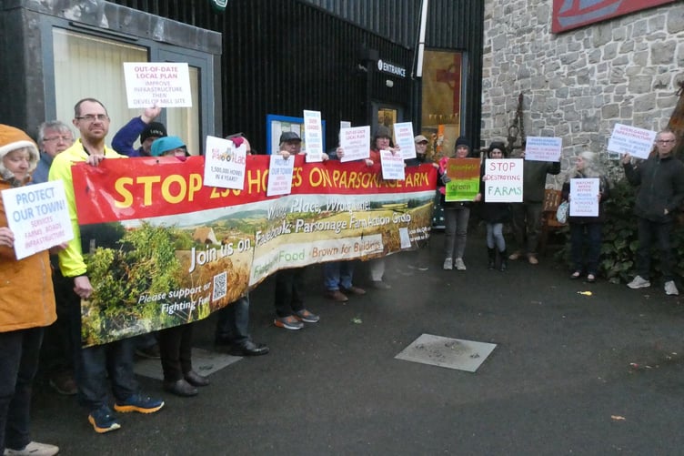 Protesters with a banner and placards attending a meeting of Watchet councillors to discuss a proposed Parsonage Farm housing development.