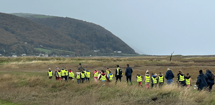 Schoolchildren walking on Armistice Day to a memorial on Porlock Marshes for 12 American airmen killed in a crash in 1942.