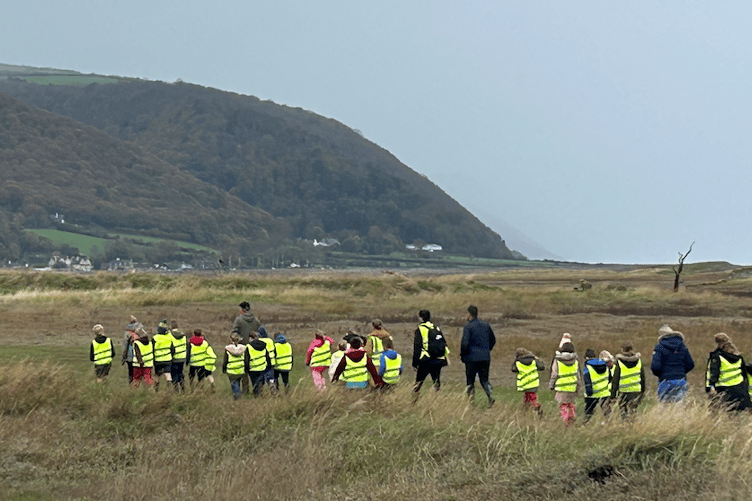 Schoolchildren walking on Armistice Day to a memorial on Porlock Marshes for 12 American airmen killed in a crash in 1942.