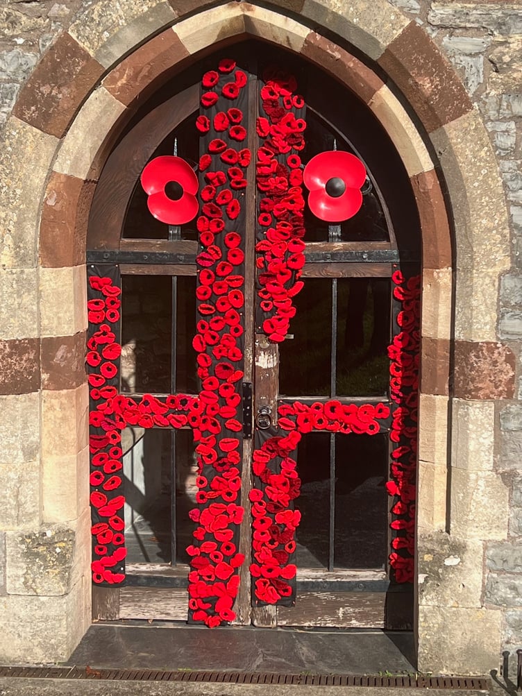 A colourful display of poppies on Carhampton Parish Church door, created by Carol Parsons and Lyn Duffield.
