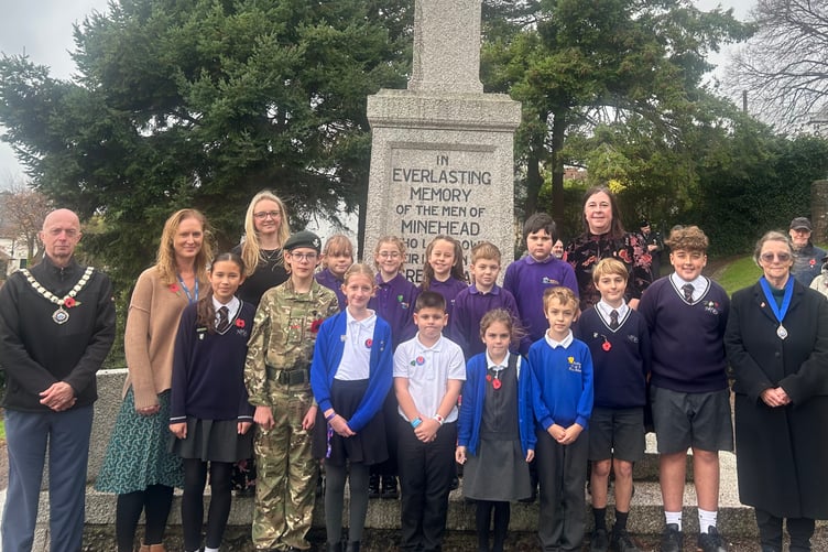 Minehead Mayor Cllr Craig Palmer at the war memorial on North Hill with pupils and staff from the town's two first schools and middle school.