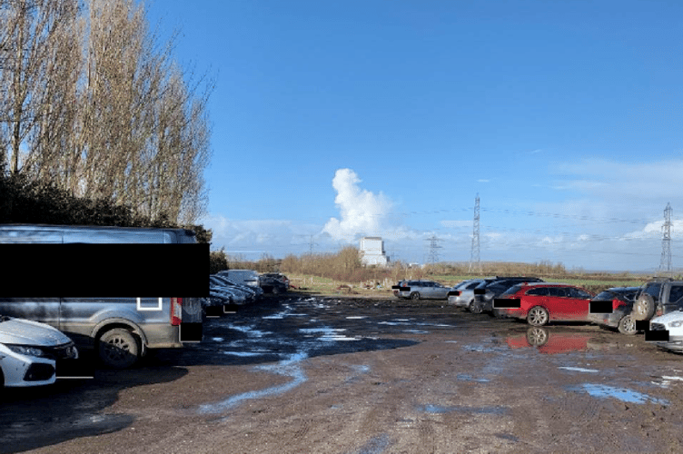 Unauthorised parking for Hinkley Point C workers in a farmyard near Stogursey, with the nuclear power station site visible in the background.
