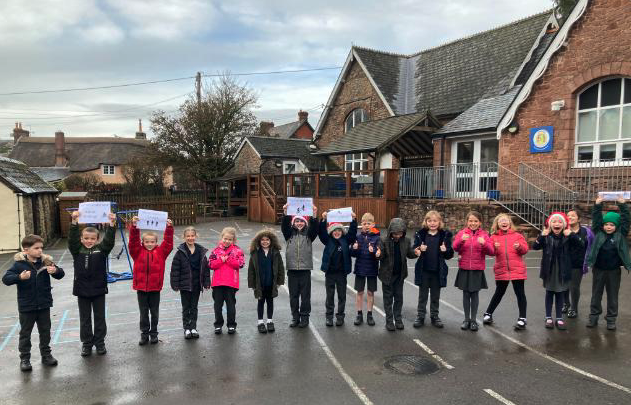 Pupils of Exford First School welcome the Moorland Federation charity cyclists.