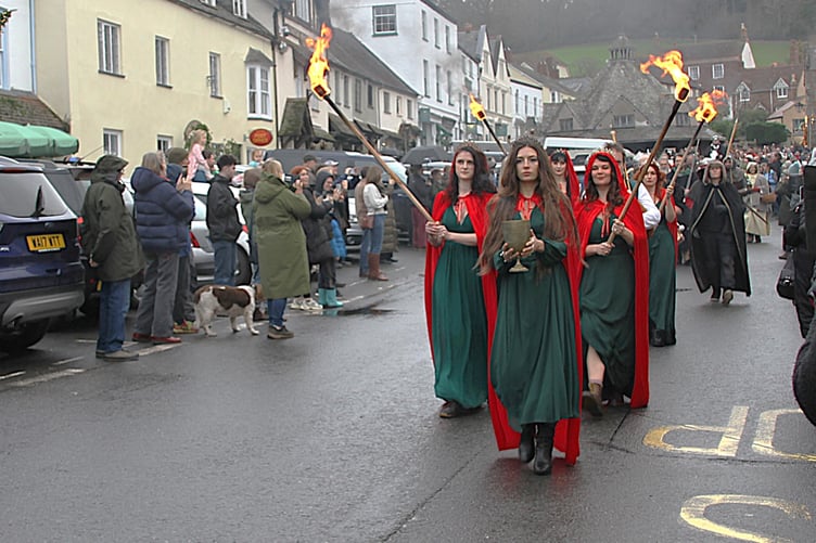 The Mediaeval Baebes lead a torchlight procession through Dunster High Street during the village's winter festival.