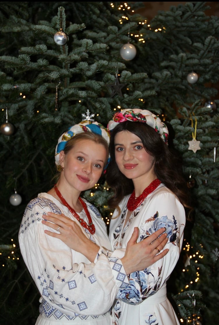 Singers Nadiia Botvynovska (left) and Bohdana Kuripko in traditional Ukrainian dress, in front of the Christmas tree in St Andrew’s Church, Wiveliscombe.