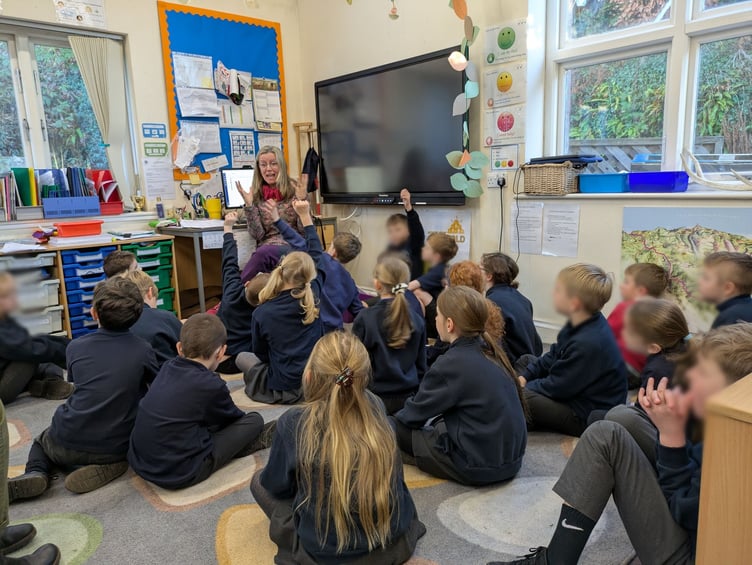 Wild Wellies Forest School founder Ema Lou Rowe with children in a classroom setting.