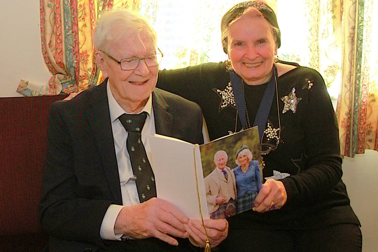 Watchet's George Lewis shows town mayor Cllr Loretta Whetlor his 100th birthday card received from the King and Queen.