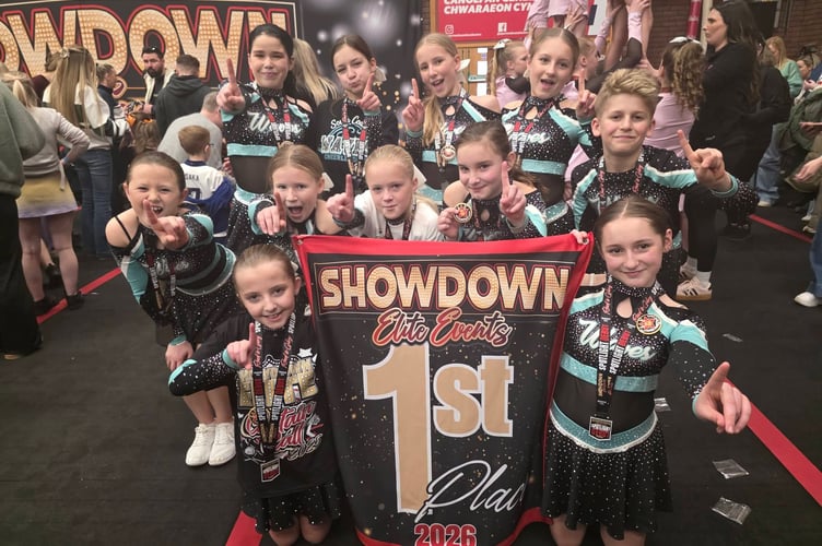 Jubilant young athletes from South Coast Waves Cheerleaders celebrate a championship-winning performance in Wales.