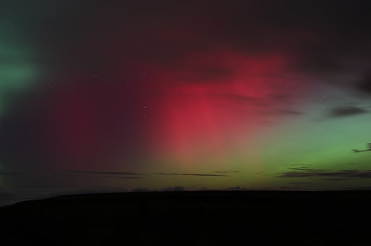 Shimmers of green and red crossing paths in the Exmoor sky.