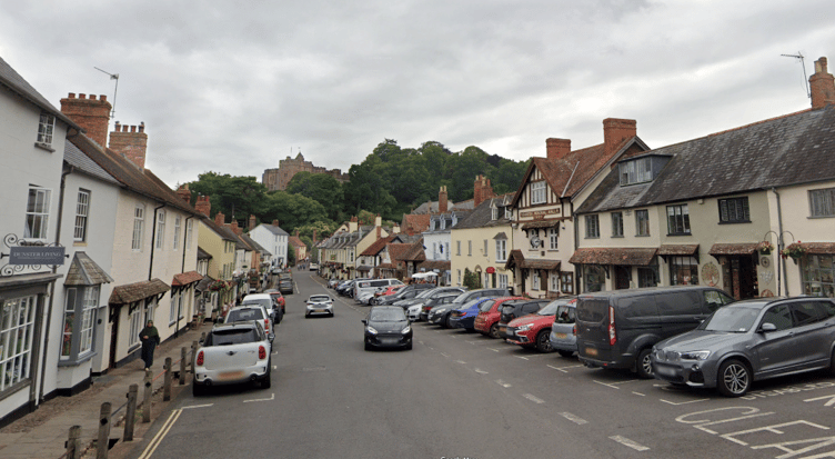Dunster High Street with Dunster Castle in the distance.
