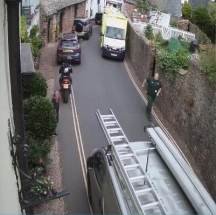 CCTV shows a paramedic rushing to try to clear traffic in Church Street, Dunster, as ambulances become stuck while on their way to a school coach crash last summer.