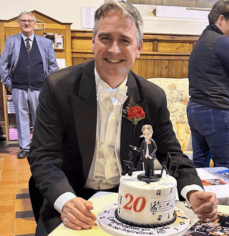Minehead Choral Society music director Marcus Capel with a celebratory cake to mark 20 years in the role.