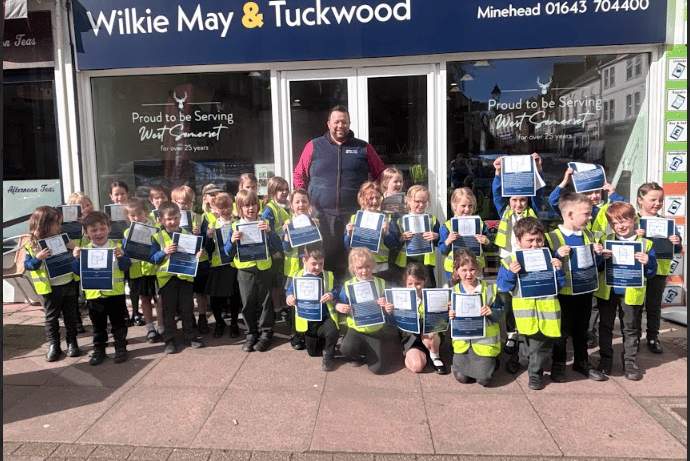 Creative writing pupils of Porlock's St Dubricius School are pictured with estate agent Richard Parsons, of Wilkie May and Tuckwood.