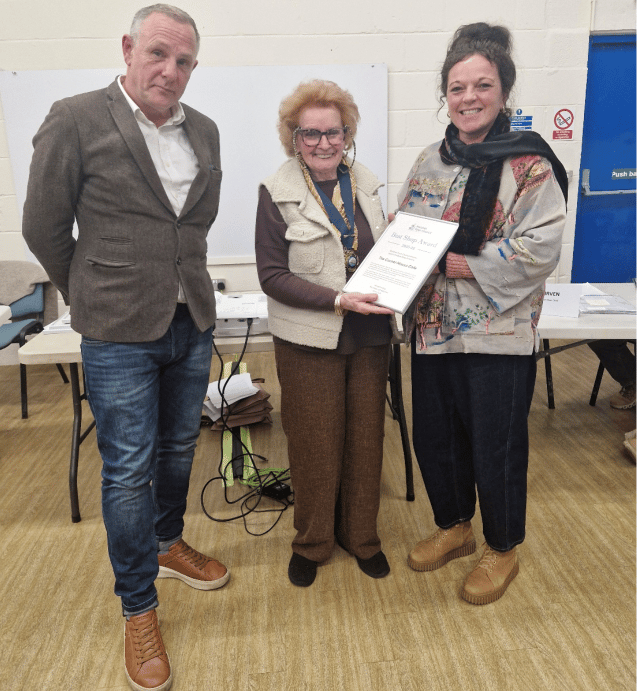Phillip and Kelly Barber, of The Corner House Café, Watchet, are presented with the town's best shop award by mayor Cllr Loretta Whetlor (centre) for being a welcoming hub for residents and visitors.