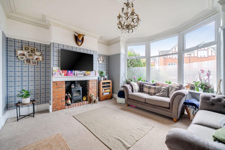 The spacious sitting room has a wood burning stove and a large bay window