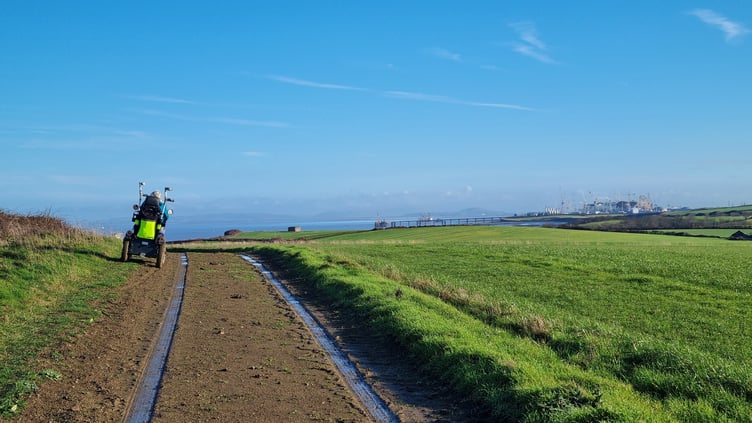 A stretch of the King Charles England Coast Path with the Hinkley Point C site in the distance.