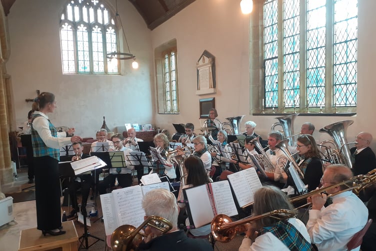 Charlotte Stus, the director of music, and members of Wiveliscombe Town Band, performing at Huish Champflower.