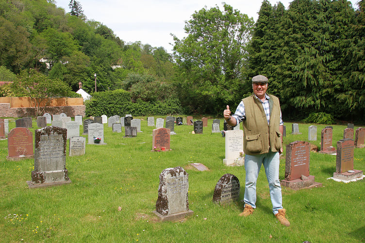 A happy Richard Growden is pictured in the now-restored Porlock Cemetery. PHOTO: George Ody.