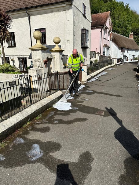 A Minehead Town Council contractor seen in 2024 using a plant-based foam product to treat weeds in Quay Street.