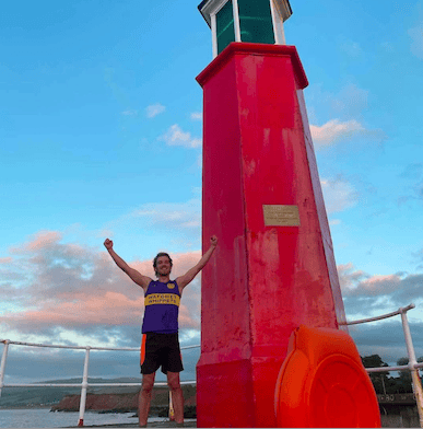 Tropiquaria Zoo's Sam Tull celebrates completion of his 52-mile run wearing Crocs as a fund-raiser for a new crocodile house.