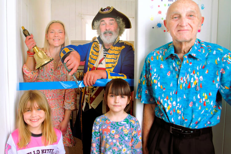 Watchet Town Crier David Milton cuts a ribbon to open a Lighthouse Basics showroom with owner Helen Griffin and Wacet chairman John Richards. Helen’s daughter Sunny Humby-Griffin and her friend Meira Murphy also attended. PHOTO: George Ody .