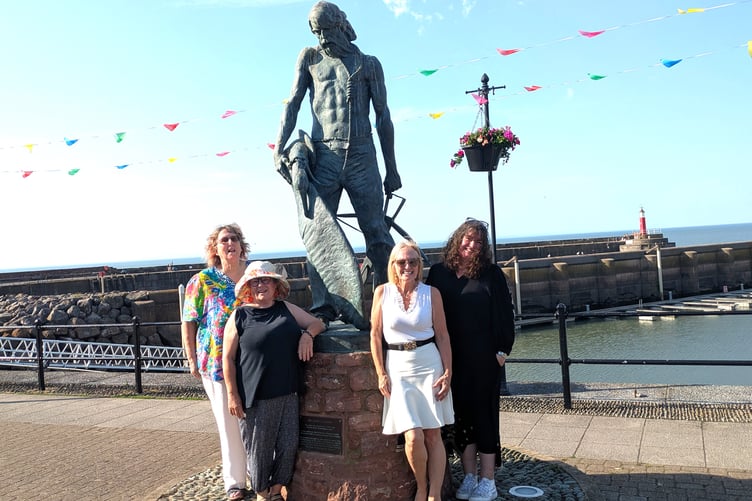 The new Mariner Community Bookshop group comprises (left to right) Rachel Irven, Anne Lovejoy, Danusia Malina-Derben, and Linda Stroud, pictured with the Ancient Mariner on Watchet Esplanade.