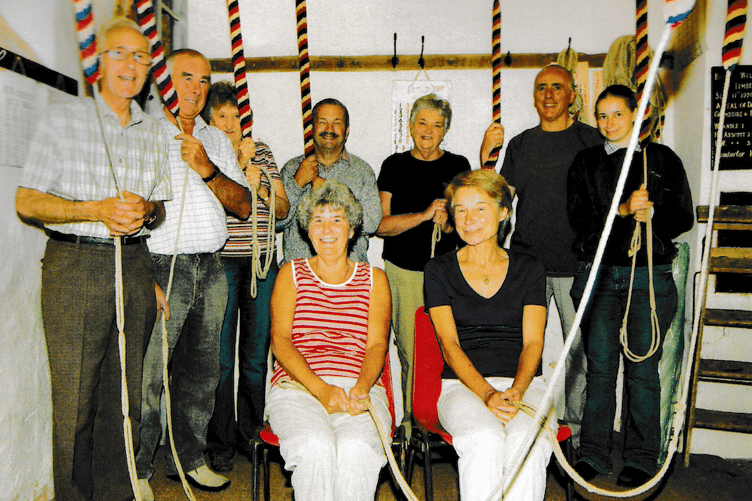 A photograph of the reformed St Petrock's Church bellringers in 2009 with Reg Holcombe (left).