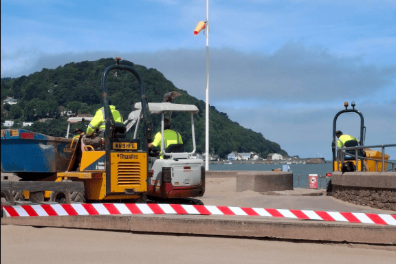 Minehead Town Council's amenities team working to return tonnes of sand from the Esplanade to the beach.