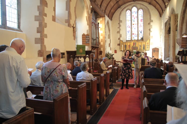 Patricia Hammond in Porlock's St Dubricius Church sang in both English and German the hymn ‘Praise to the Lord, the Almighty’ as part of a rededication service for a wartime fallen German airman. PHOTO: George Ody.