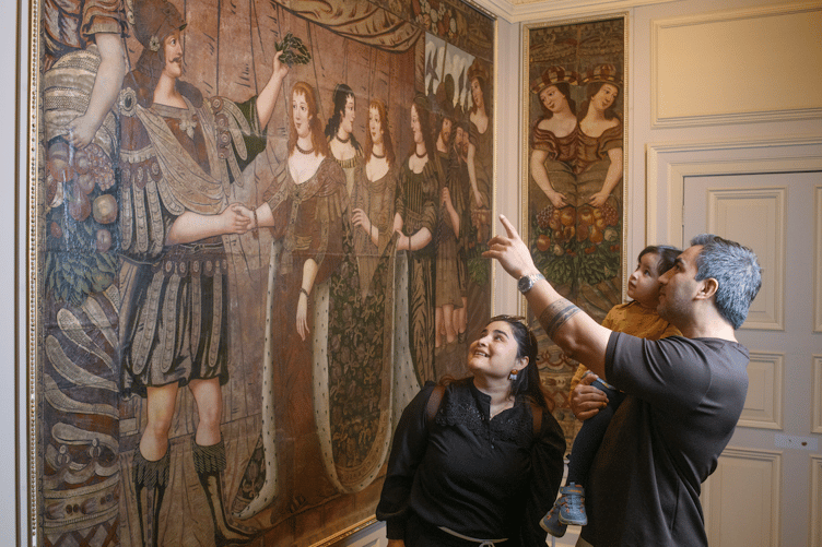 A father explains one of the Dunster Castle leather hangings to his family. PHOTO: National Trust/Steve Haywood.