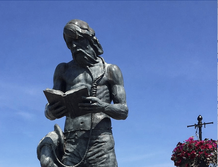 A computer-generated image of Watchet's Ancient Mariner sculpture with a book in his hand. IMAGE: Words in Watchet.